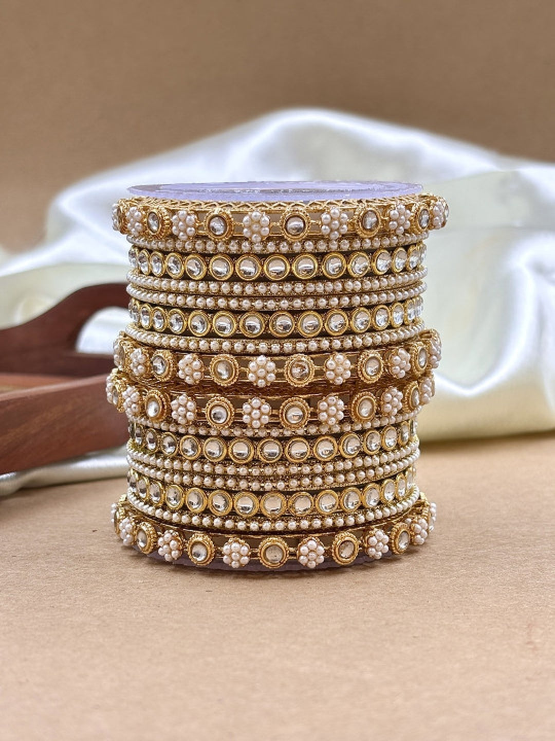 Ishhaara Kundan Bangles Set - a stack of gold bangles with kundan and pearl embellishments