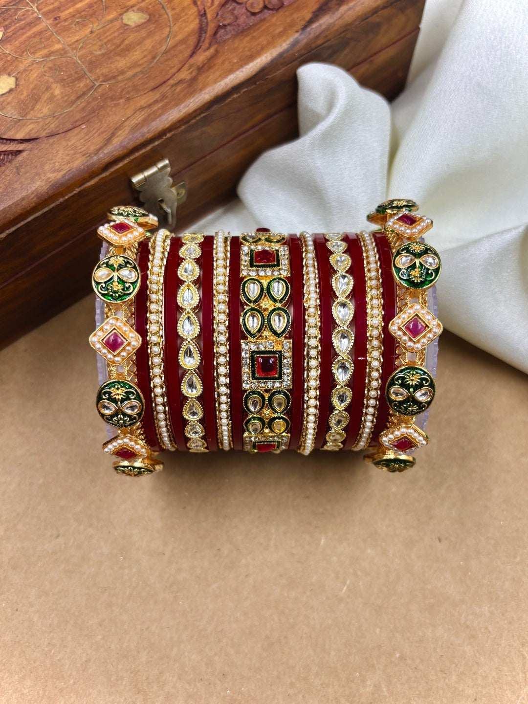 Ishhaara Maroon Kundan Bangle Set - a woman wearing a maroon top and gold kundan bangles - view 2