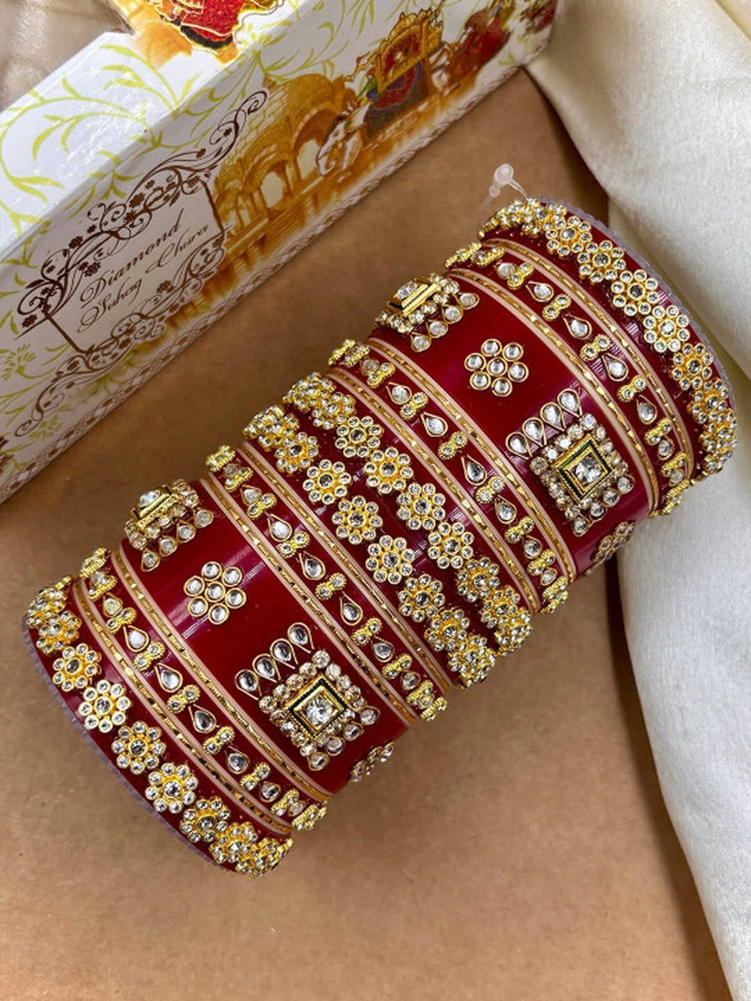 Ishhaara Red Kundan Bangles - A pair of intricately designed red kundan bangles with gold and stone embellishments