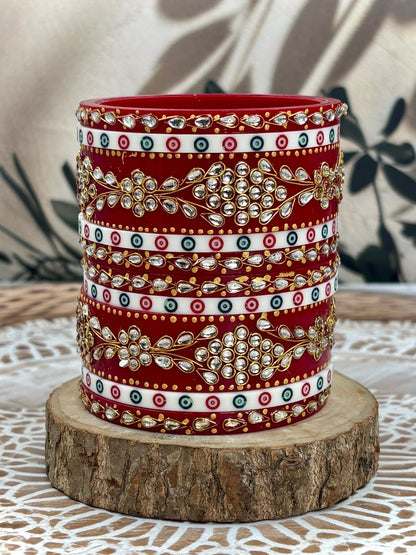 Ishhaara Red Kundan Bangles Set - A stack of intricately designed red bangles with clear stones